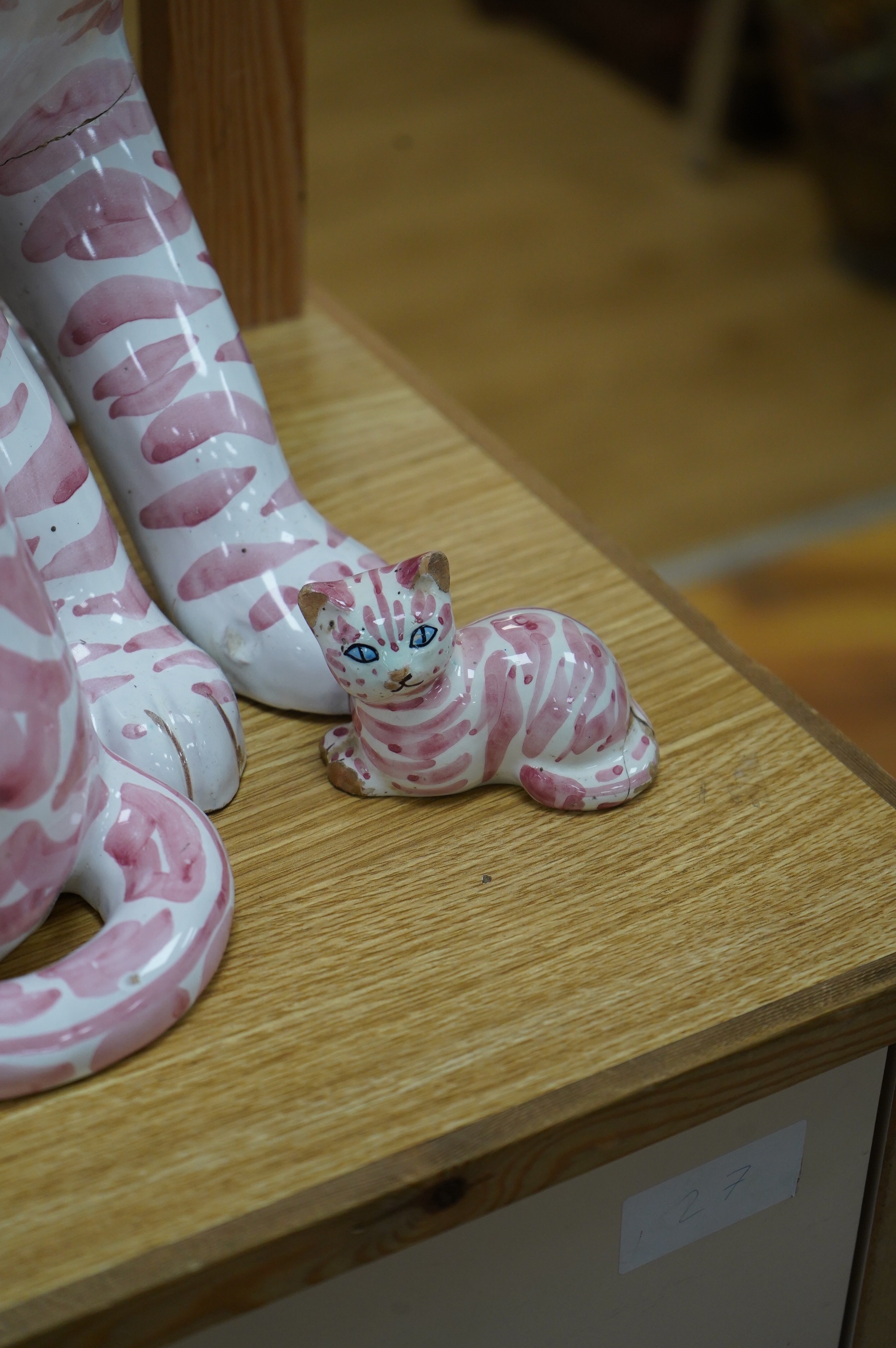 A large 1950's Italian pink maiolica seated cat and two smaller, largest 45cm. Condition - poor